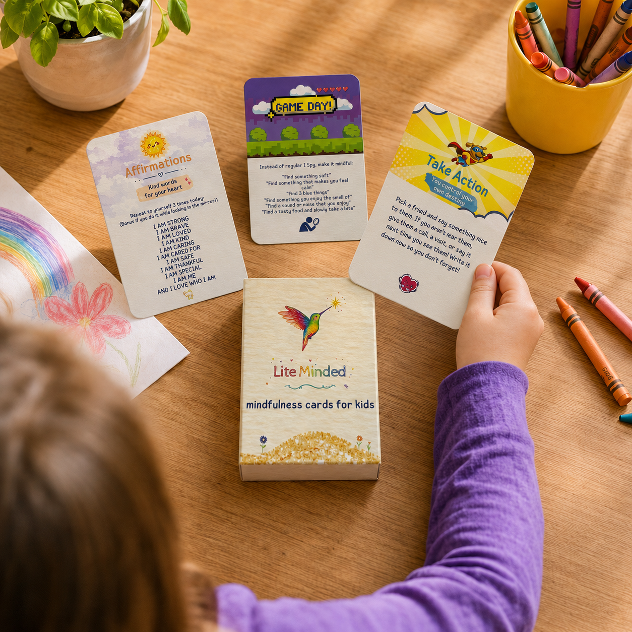 Child choosing an affirmation card from the Lite Minded Mindfulness Cards for Kids deck at a table.