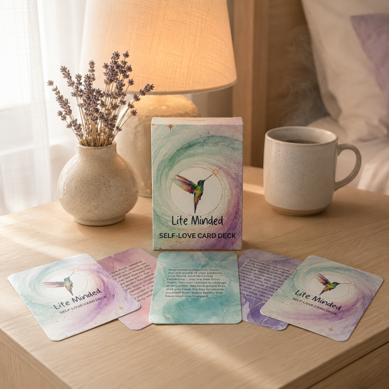 Self-Love affirmation card deck box and cards on a nightstand with a lamp, lavender, and mug